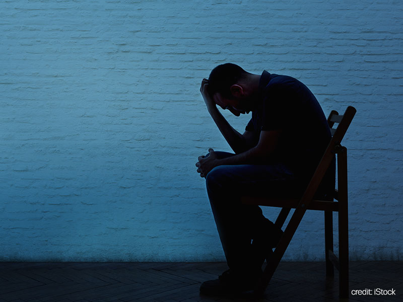 Seated man looking despondent