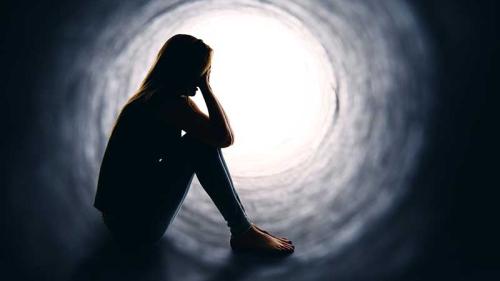 Silhouette of woman sitting inside tunnel