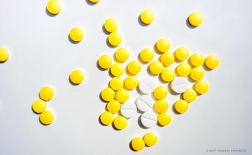 yellow and white pills on a light grey background