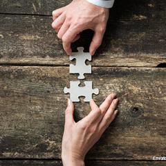 2 hands joining 2 jigsaw pieces