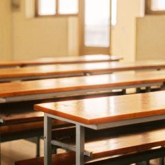 image of long brown tables and stools in classroom