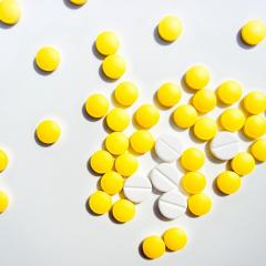 yellow and white pills on a light grey background
