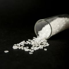 lab tube with spilled cathinone white salt on black background