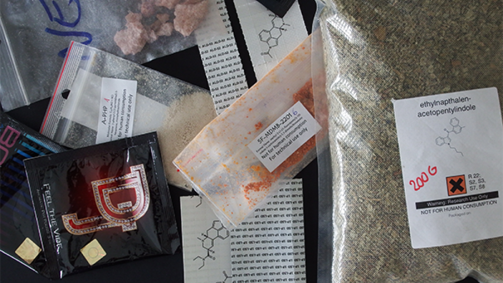 Powders, herbal mixtures and crystals in different packages and sachets placed on a table