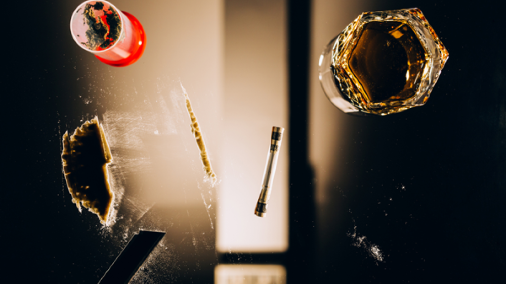 View through a glass table with a glass of alcohol, powder and a syringe