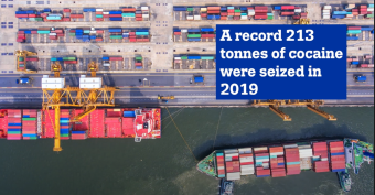 Image of a port with container ships seen from top with the text 'A record 213 tonnes of cocaine were seized in 2019'